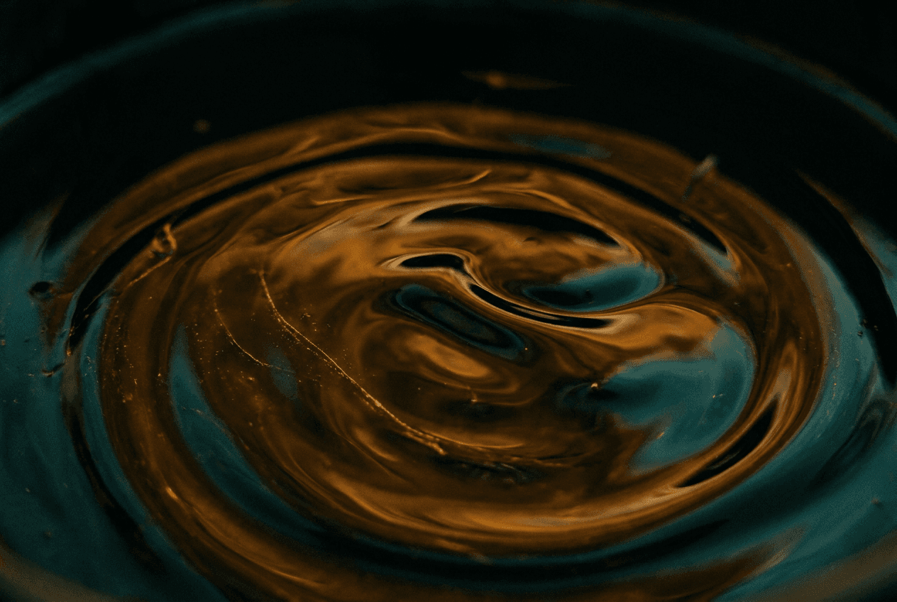 Macro detail of crude oil surface catching amber and teal light